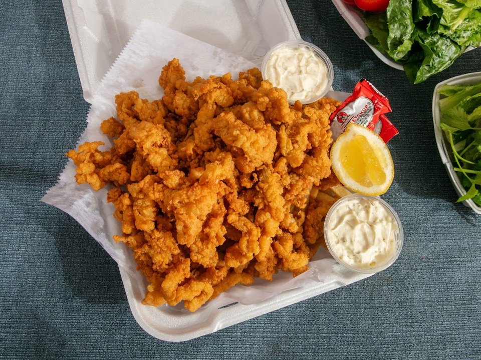 Menu board for seafood, chicken tenders, and wings.